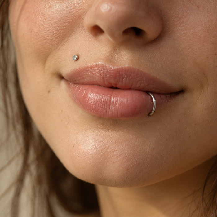 Woman with a small stud above her upper lip and a silver hoop in her lower lip