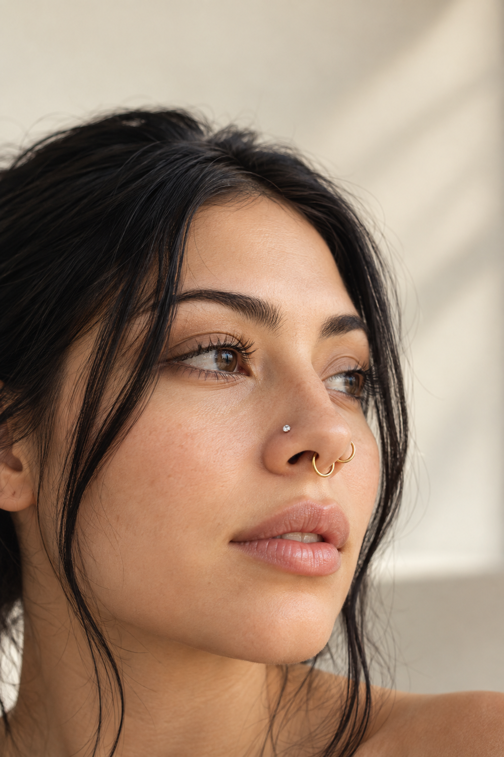 Woman with a nostril stud and gold nose hoops