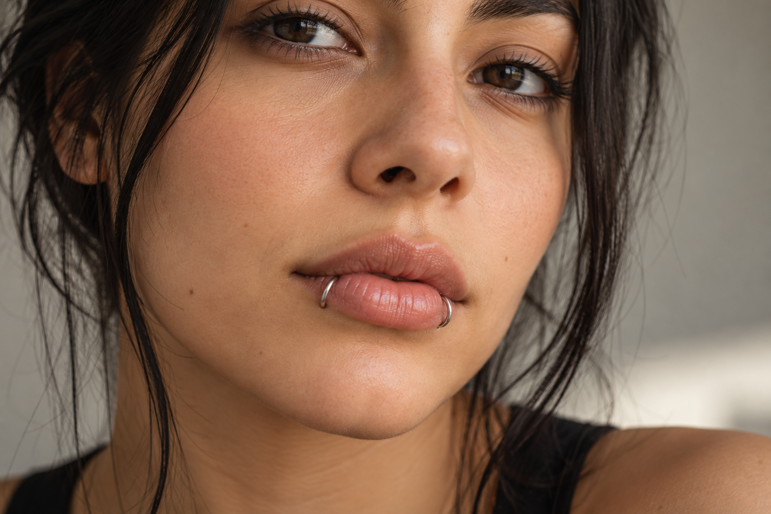 Woman with snake bite piercings: a silver hoop on each side of her lower lip