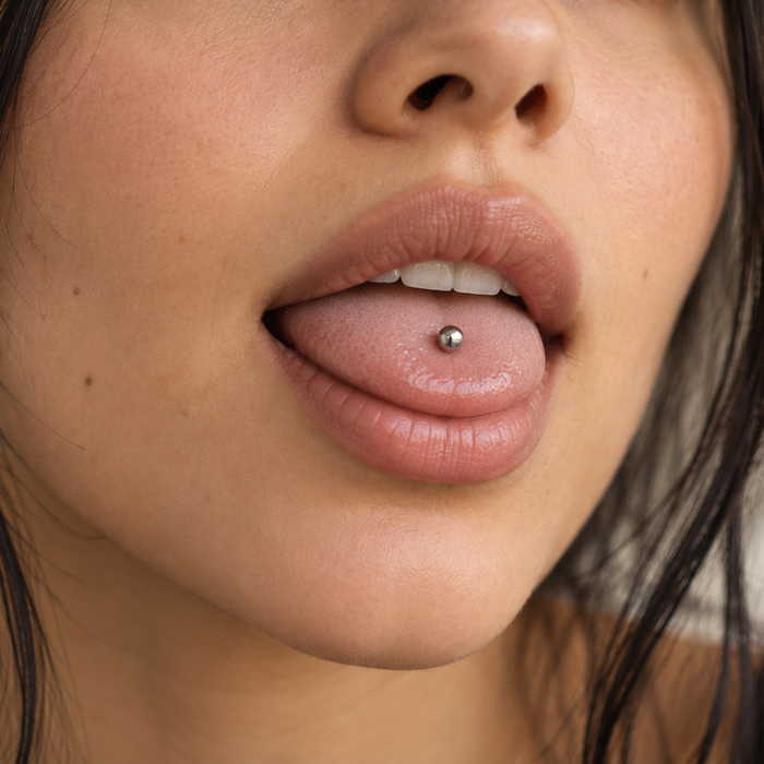 Woman with a healed midline tongue piercing: a single silver ball in the center of her tongue