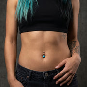 14G surgical steel belly button ring with a turquoise stone and steel top ball, worn in a navel piercing.