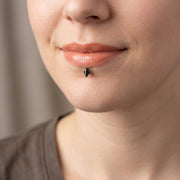 16G surgical steel labret stud with a black 3mm spike, shown worn in a labret lip piercing.