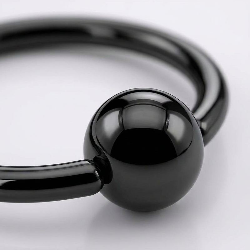 18G PVD coated steel nose ring with a glossy black fixed ball, close-up detail on a white background