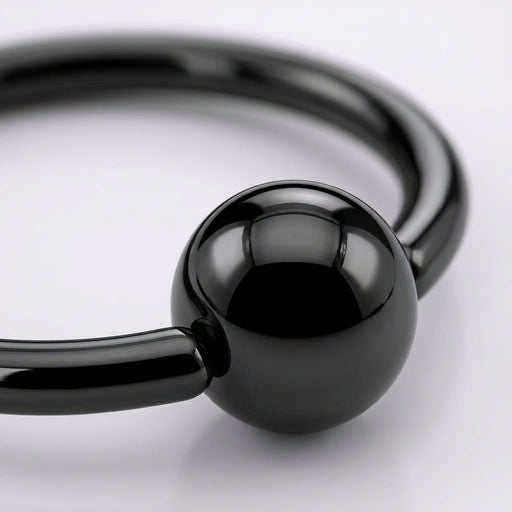 18G PVD coated steel nose ring with a glossy black fixed ball, close-up detail on a white background