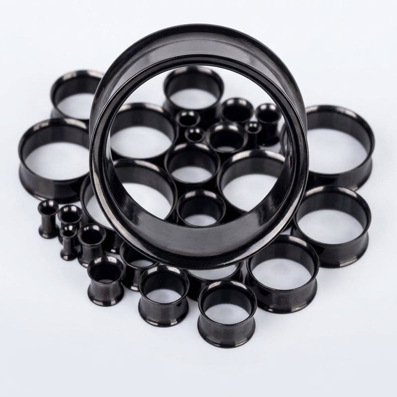 6G-1" PVD coated steel double flared eyelets with a black finish, assorted sizes in a pile, close-up detail