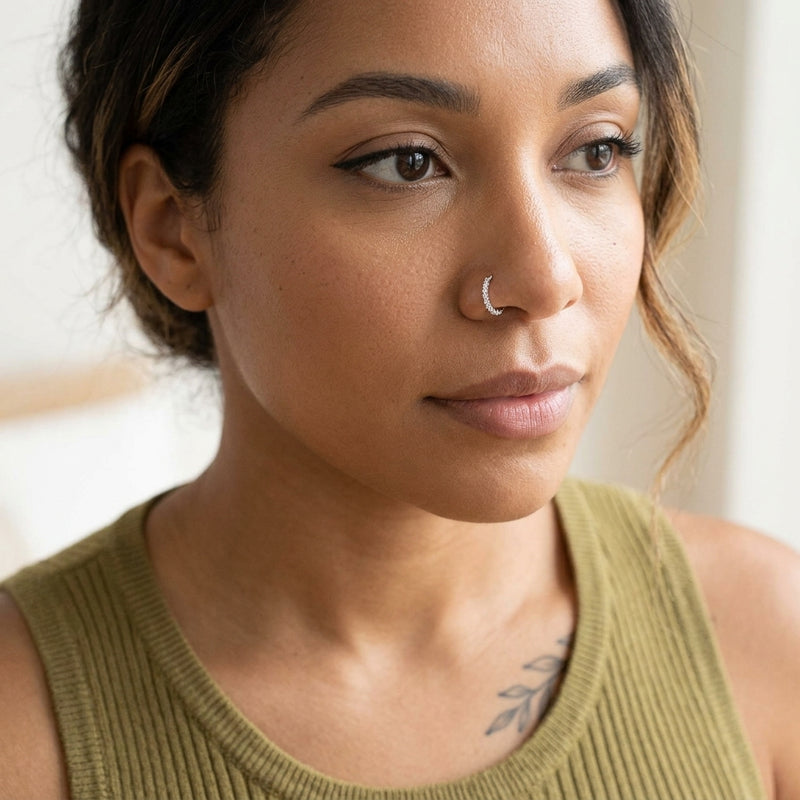 20G cubic zirconia bendable hoop with clear CZ gems, shown worn in a nostril piercing.