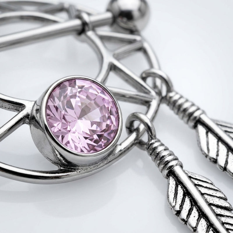 14G surgical steel nipple shield with a dream catcher design, pink gem, and dangling feathers, close-up