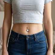 14G surgical steel navel ring with a white glitter opal heart gem, worn in a navel piercing