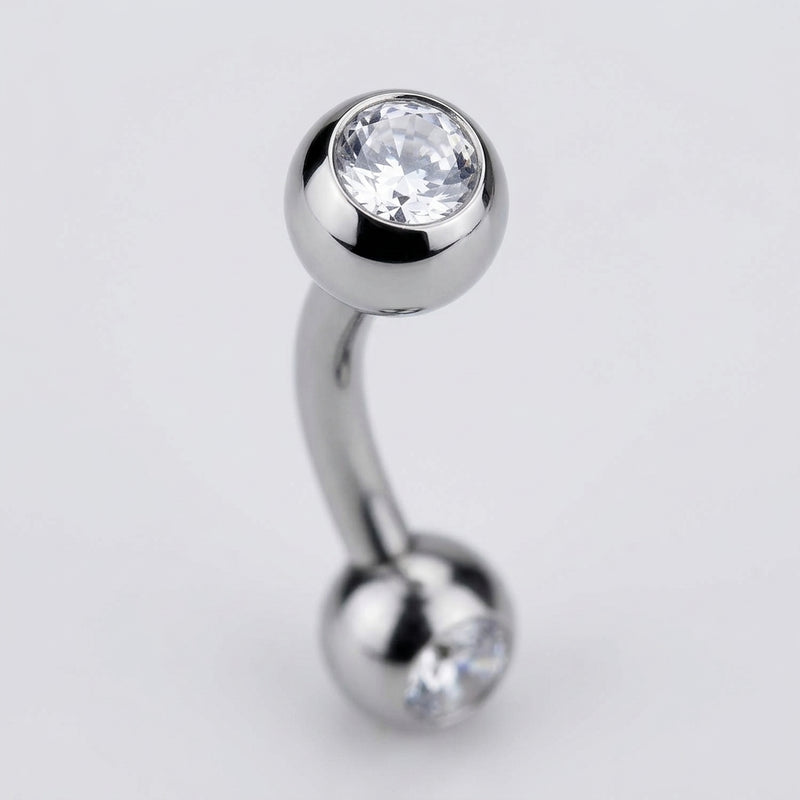 16G titanium curved eyebrow barbell with bezel-set clear CZ gem balls, close-up detail