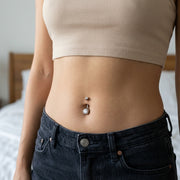 14G titanium curved navel ring with clear CZ gem balls, shown worn in a navel piercing