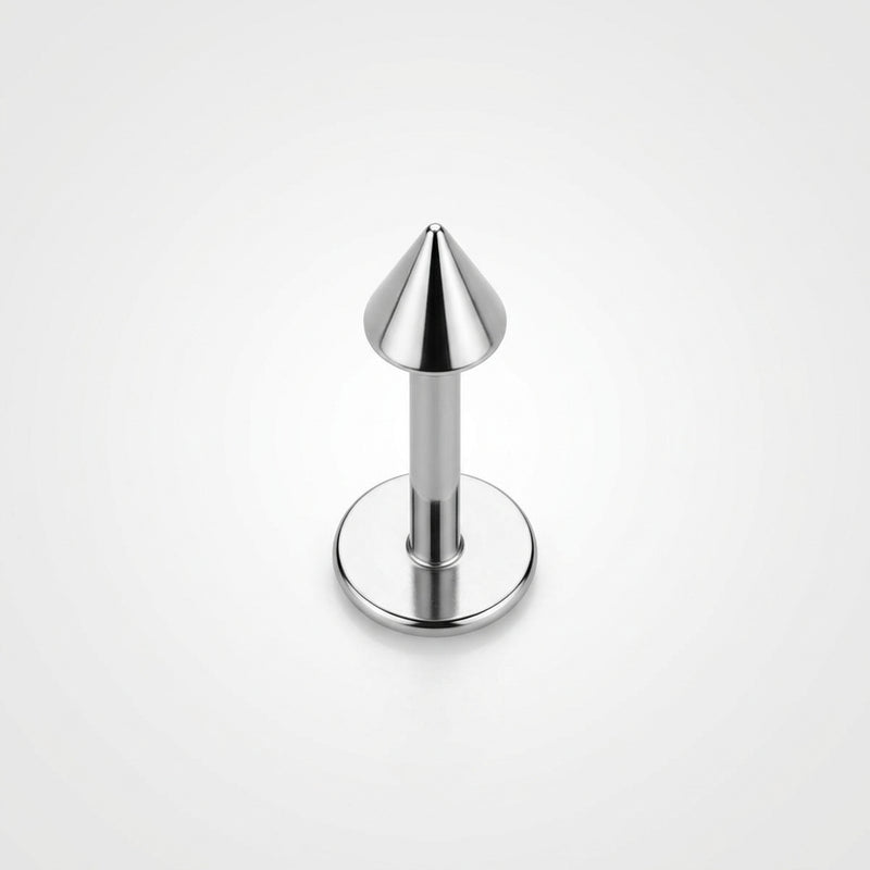 16G titanium labret stud with a flat back disc and polished cone spike end, standing upright on white