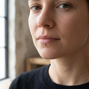 16G titanium labret stud with a silver spike end, shown worn in a lower lip piercing