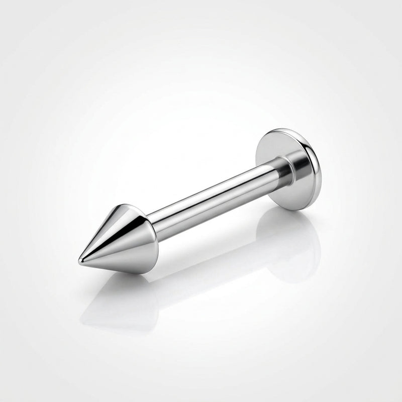 16G titanium labret stud with a spike end and flat back, three-quarter view on a reflective white surface