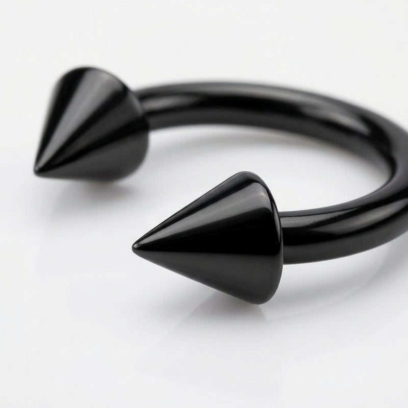 14G black PVD coated steel circular bent barbell with spike ends, close-up detail on a white surface