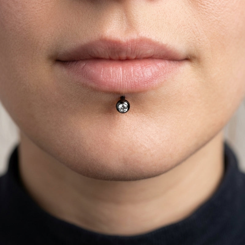 16G black surgical steel labret stud with a 3mm clear CZ gem ball, worn in a lip piercing