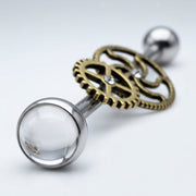 14G surgical steel industrial barbell with brass steampunk gears, clear CZ gems, and a clear dome end, close-up