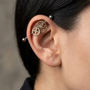 14G surgical steel industrial barbell with bronze steampunk gears and clear gems, worn in an industrial ear piercing.