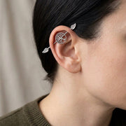 14G surgical steel industrial barbell with tree of life design and leaf ends, worn in an industrial ear piercing.