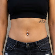 14G titanium navel ring with double clear round CZ gems, shown worn in a navel piercing.