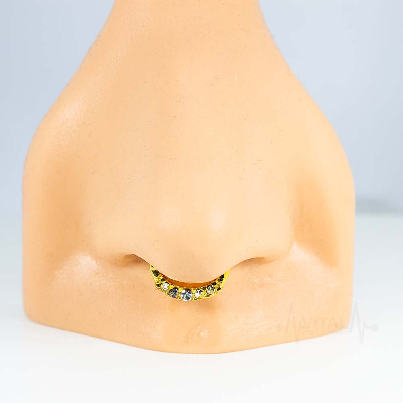 16G surgical steel septum clicker with five cubic zirconia gems, PVD coated for a durable gold finish and secure clicker mechanism.