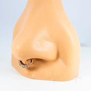 16G surgical steel septum clicker with five cubic zirconia gems and a rose gold PVD coated finish for an elegant look