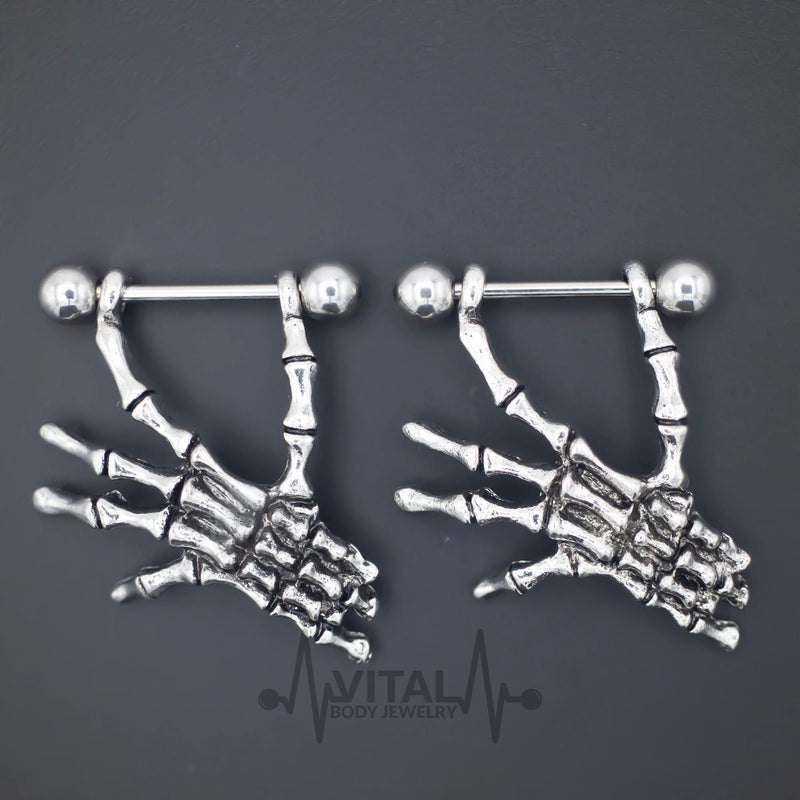 14G surgical steel nipple rings with dangle skeleton hands design for a striking gothic style and comfortable wear.