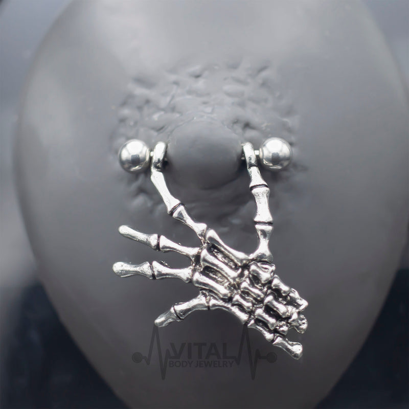 14G surgical steel nipple rings with dangling skeleton hands design for a unique and gothic style, perfect for expressing individuality.