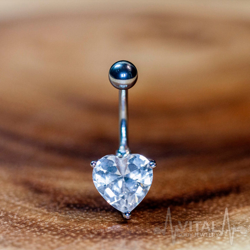 14G surgical steel belly ring with heart-shaped cubic zirconia gem for elegant body jewelry style.