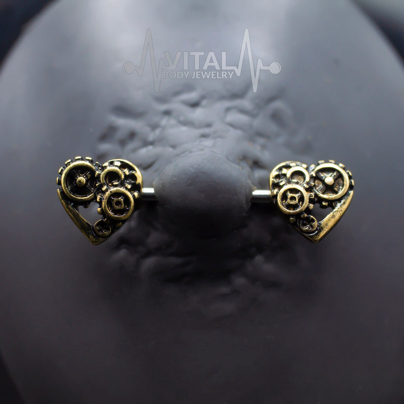 14G surgical steel nipple barbell with steampunk heart design in antique gold and silver finishes for a bold statement